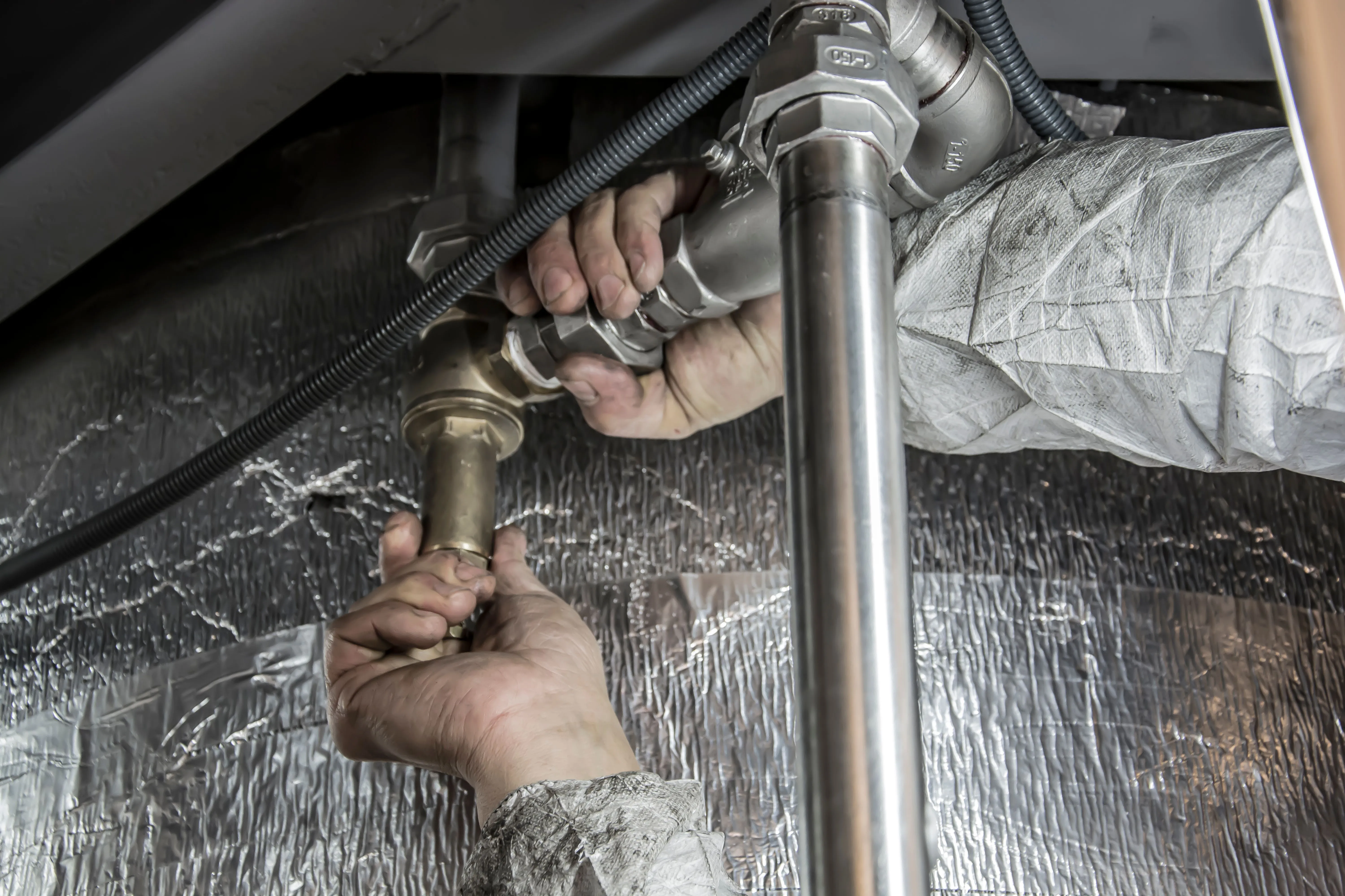 Plumber repairing a slab leak pipe beneath a Phoenix home